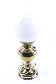 A converted brass oil lamp. With glass chimney and white globe shade.