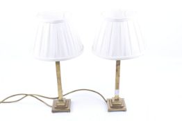 A pair of brass table lamps. On a stepped base with ball feet.