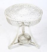 A cane work circular garden table. Painted white, with a circular top on tripod support, H65.