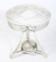 A cane work circular garden table. Painted white, with a circular top on tripod support, H65.