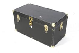 A contemporary Mossman black travel trunk. With brass fittings and corners, keys present.