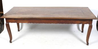A French style wooden dining table. With curved square tapering supports.