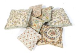 A collection of seven assorted embroidered covered cushions. Max. 46cm x 46cm.