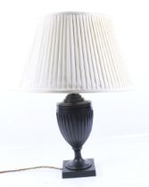 A contemporary bronzed classical urn shaped table lamp. On a square base, with cream shade.