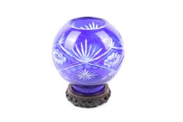 A Victorian cased cobalt blue cut glass globe vase. On a hardwood stand.