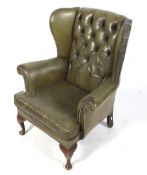 A green leather wingback armchair.