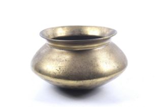 An Indian heavy brass cooking pot. With everted lip rim, spread waist and rounded base.