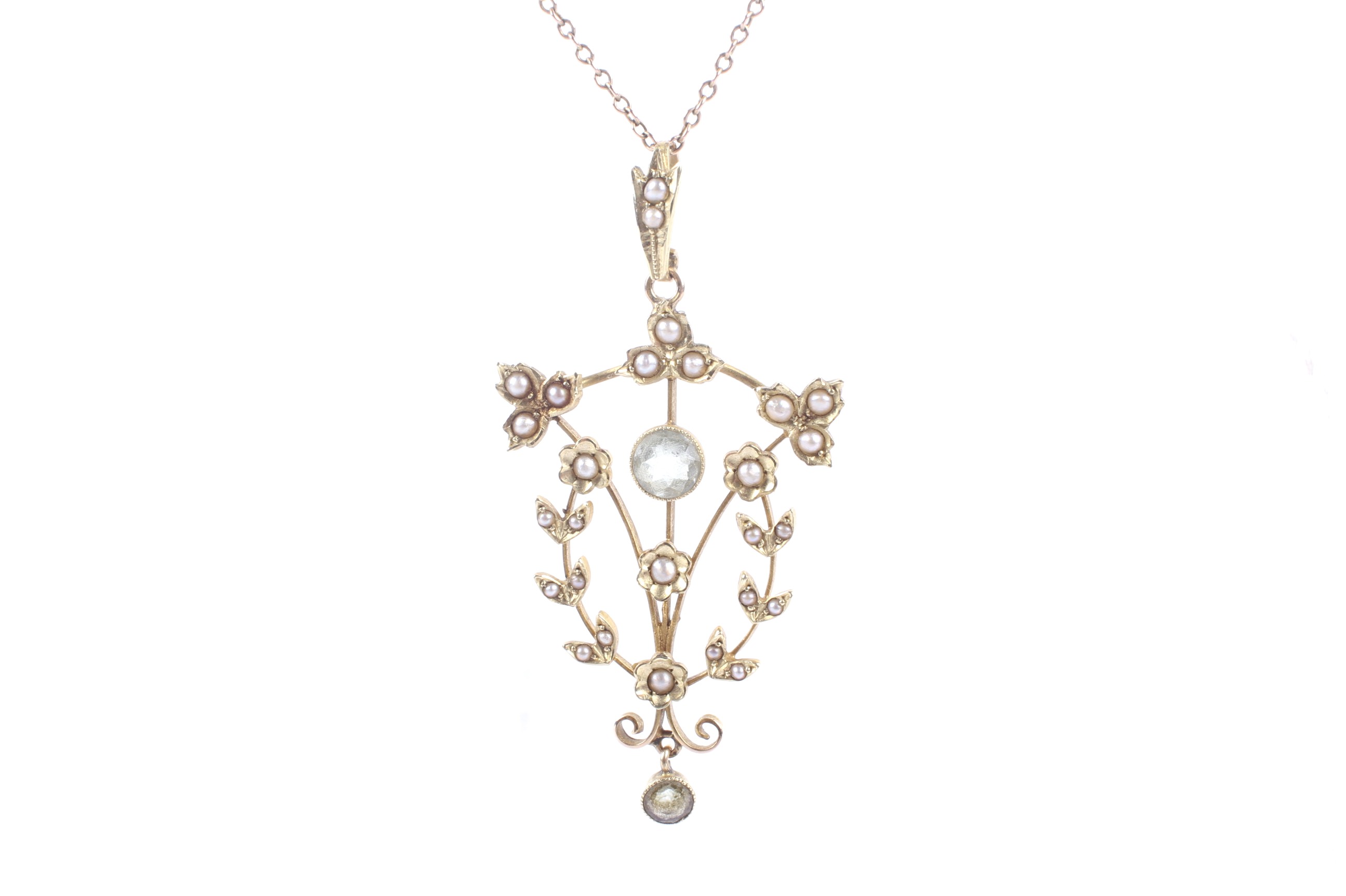 An Edwardian gold, aquamarine and seed pearl open flower and leaf pendant. Stamped '15ct', approx.