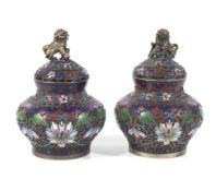 A pair of Chinese champleve and cloisonne enamel lidded vessels.