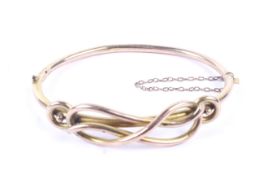 A late Victorian 9ct rose gold hollow knot bangle.