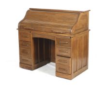 An early 20th century oak roll top desk stamped to lock 'Angus London'.