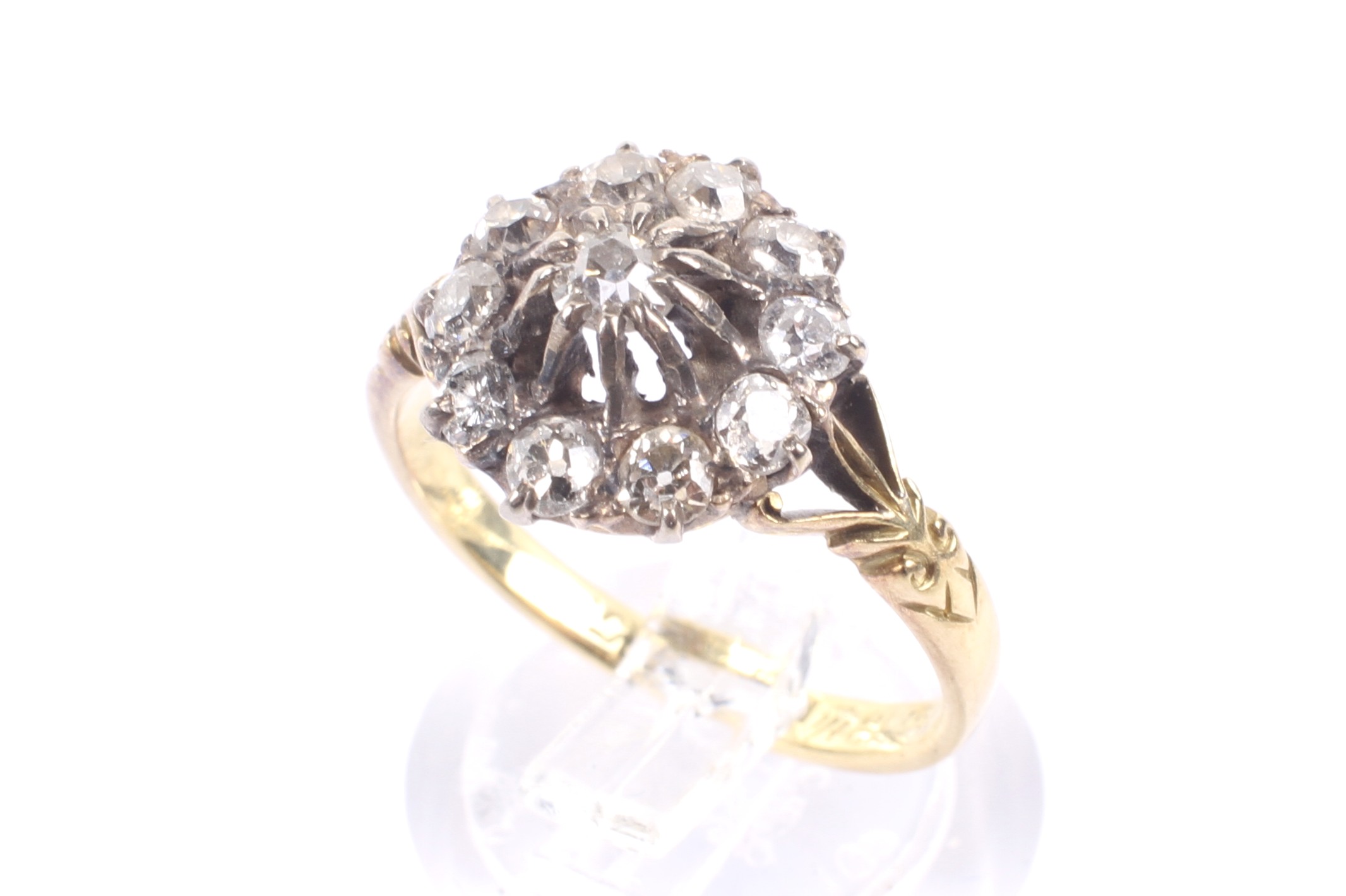 An early 20th century gold and diamond cluster ring. The 11 old-cut stones approx. 1.