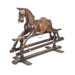 A 20th century stained wood rocking horse. With alert ears, brown eyes and open mouth, with saddle.