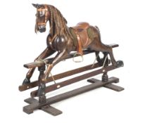 A 20th century stained wood rocking horse. With alert ears, brown eyes and open mouth, with saddle.