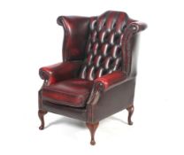 A 20th century oxblood leather wingback armchair.