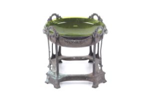 An Edwardian metal bowl on stand. The bowl containing a later green glass insert.