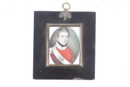 An ivory miniature portrait in an ebonized wooden frame, with bras sborder and acorn hanging ring.