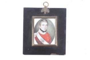 An ivory miniature portrait in an ebonized wooden frame, with bras sborder and acorn hanging ring.