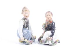 Pair of Royal Copenhagen porcelain figures in National dress with flowers.