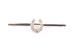 A late Victorian gold and diamond 'horseshoe' bar brooch. The nine graduated old-cut stones approx.