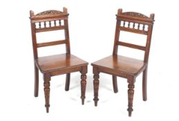 A pair of late Victorian walnut hall chairs.