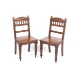 A pair of late Victorian walnut hall chairs.