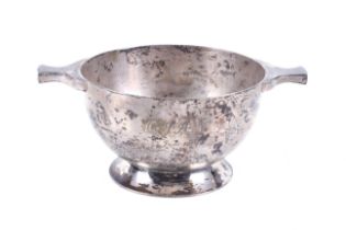 A silver round sugar bowl in the form of a quaich.
