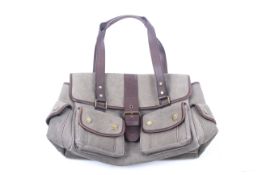 A Barbour canvas handbag. In green with tartan lining and leather straps.