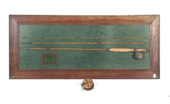 A vintage three piece fishing rod mounted on a wooden board.