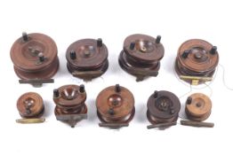 Nine vintage wooden 'Strap back' fishing reels.