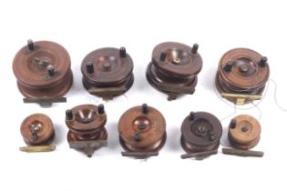 Nine vintage wooden 'Strap back' fishing reels.