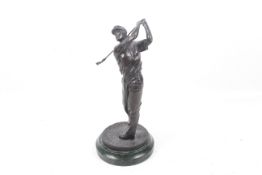 A bronze sculpture of a golfer on marble base. Shown finishing his swing, H33cm.