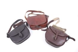 A collection of three leather cartridge bags. In black, brown and tan with canvas slings.
