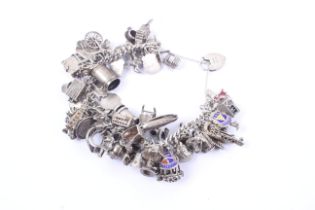 A silver 'charm' bracelet hung with a multitude of charms, 147g gross.