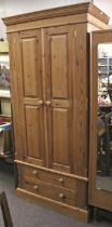 A 20th century double door pine wardrobe. With hanging rail and two lower drawers.