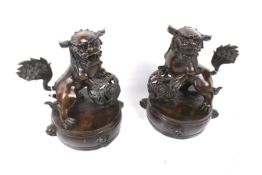 A pair of Chinese bronze Fo dogs. On integral circular base.