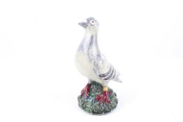 An indistinctly signed Portuguese ceramic figurine of a racing pigeon.