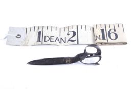 A pair of early 20th century tailor's shears and a Dean novelty tape measure.