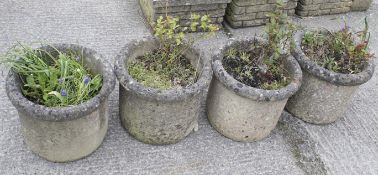 A set of four reconstituted stone round garden planters.