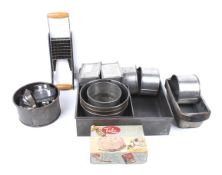 A collection of assorted vintage cake tins, biscuit cutters and other kitchenalia.