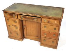 An Edwardian pine knee hole desk with green inset leather top.