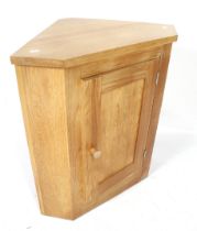 A contemporary oak corner cupboard. With single panelled door.