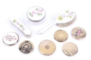 Six compacts and a guilloche enamelled three-piece part dressing table set.