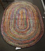An Indian hand made braided Chindi oval rag rug.