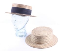 Two vintage straw boater hats and a glass headstand.