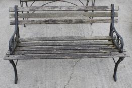 A two seater garden bench with cast metal ends.