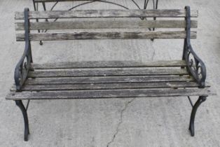 A two seater garden bench with cast metal ends.