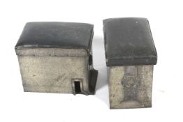 A pair of hammered metal storage units, possibly once part of a fire fender.
