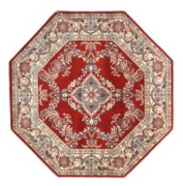Two octagonal red ground wool rugs.