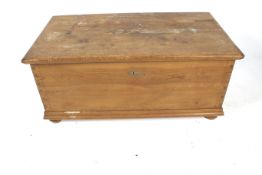 A large pine blanket box. With inner narrow hinged compartment, all raised on bun feet.
